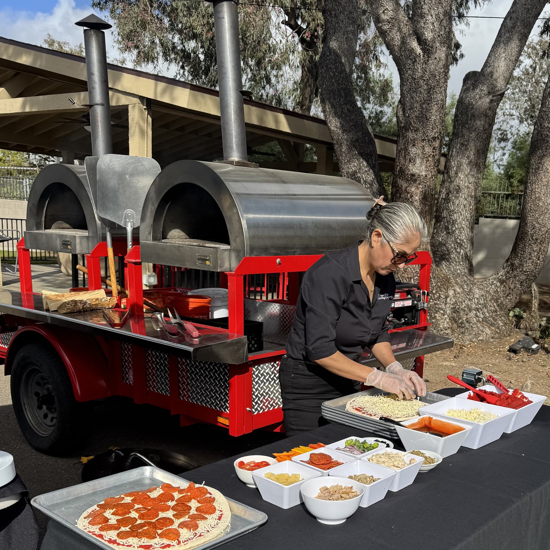 Preparing fresh wood fired pizza for catering events